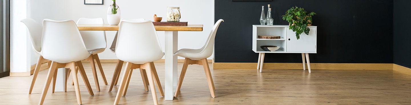 Tisch mit Stühlen in Raum mit schönem Parkett