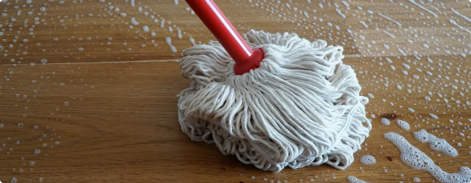 Wischmopp wischt Parkettboden